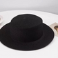Woven paper straw sun hat shown from the side showing the flat top and wide brim