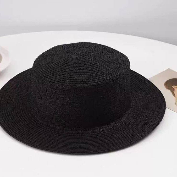 Woven paper straw sun hat shown from the side showing the flat top and wide brim