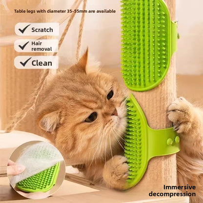 Green rubber cat self groomer strapped to a table leg while a ginger cat rubs its cheek against the bristles