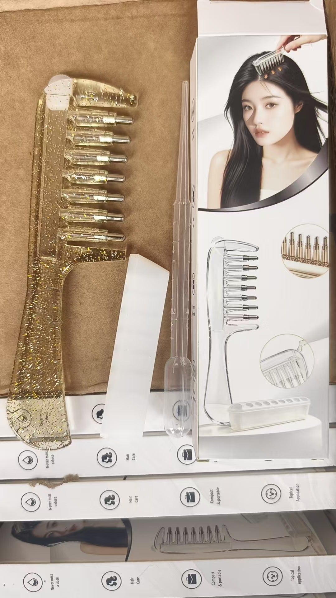 Transparent scalp massage comb with rounded tips positioned next to its printed retail box
