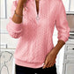 Close view of the raised cable knit texture on a polyester quarter zip pullover
