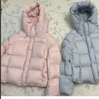 Pastel hooded down puffer jacket laid flat showing the drawcord hood and box quilting