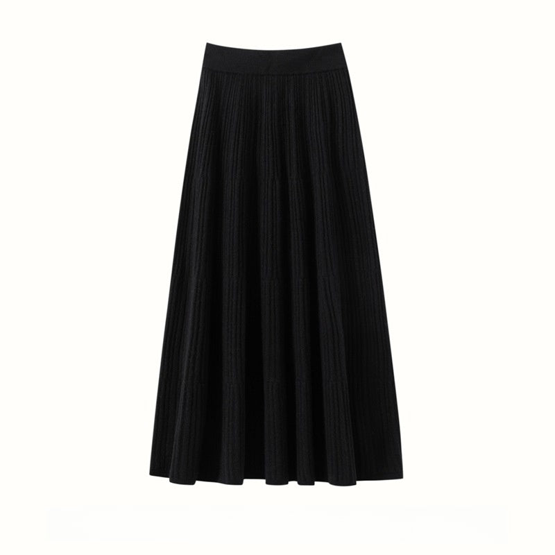 Black ribbed A-line midi skirt with tiered seams and a wide waistband, flat view on a white background