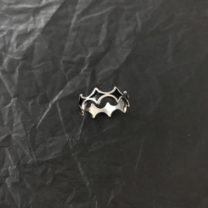 Macro of the steel ring on black paper showing dark diamond fields framed by polished raised ridges