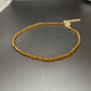 Faceted glass bead necklace coiled to show the choker length and extender