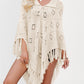 Knit cape poncho with collar tie and openwork stitch shown on a model with fringe hem