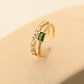 Angled view of the Emerald Open Ring with the faceted green zircon centered between two bands