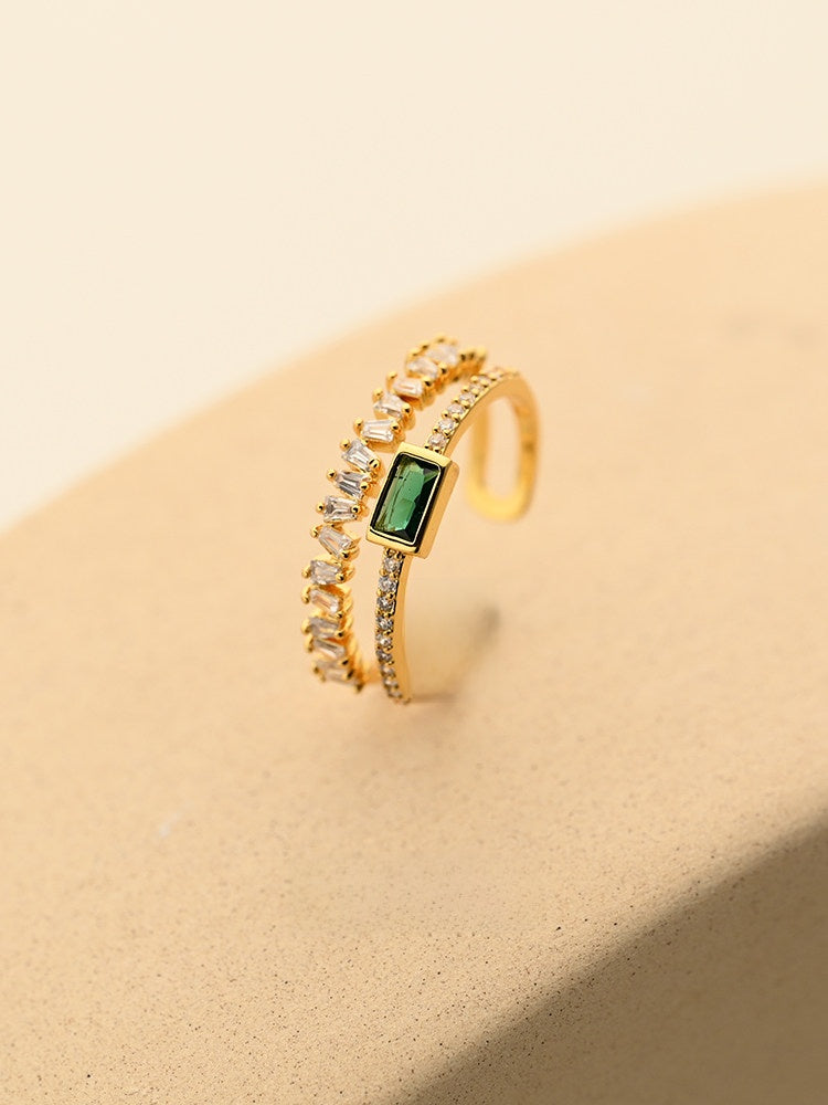 Angled view of the Emerald Open Ring with the faceted green zircon centered between two bands