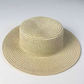 Top view of a woven straw sun hat showing the spiral braid of the flat crown