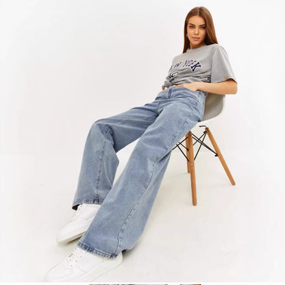 Woman seated in light wash wide leg baggy jeans