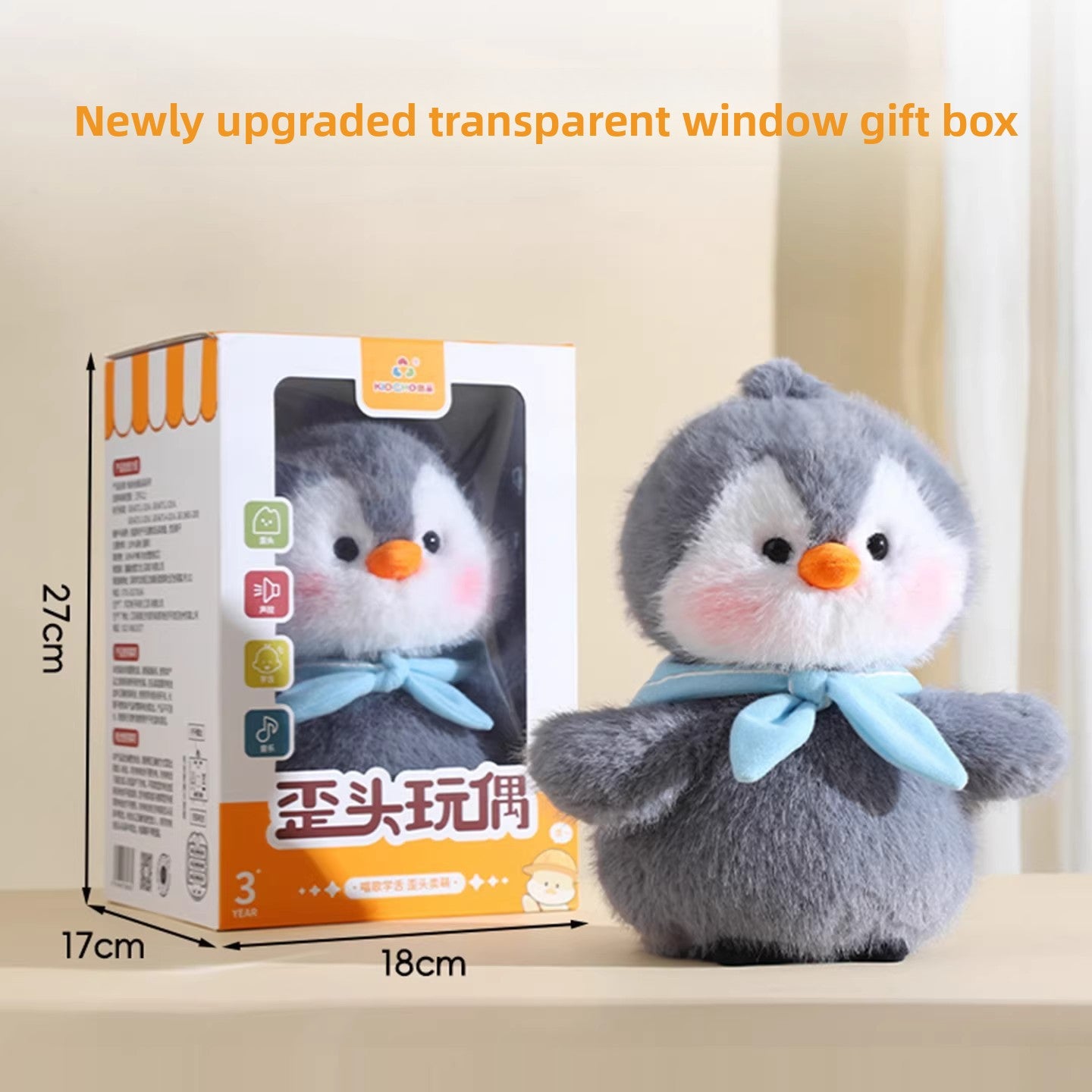 Penguin plush next to its window gift box showing 27 by 17 by 18 cm size