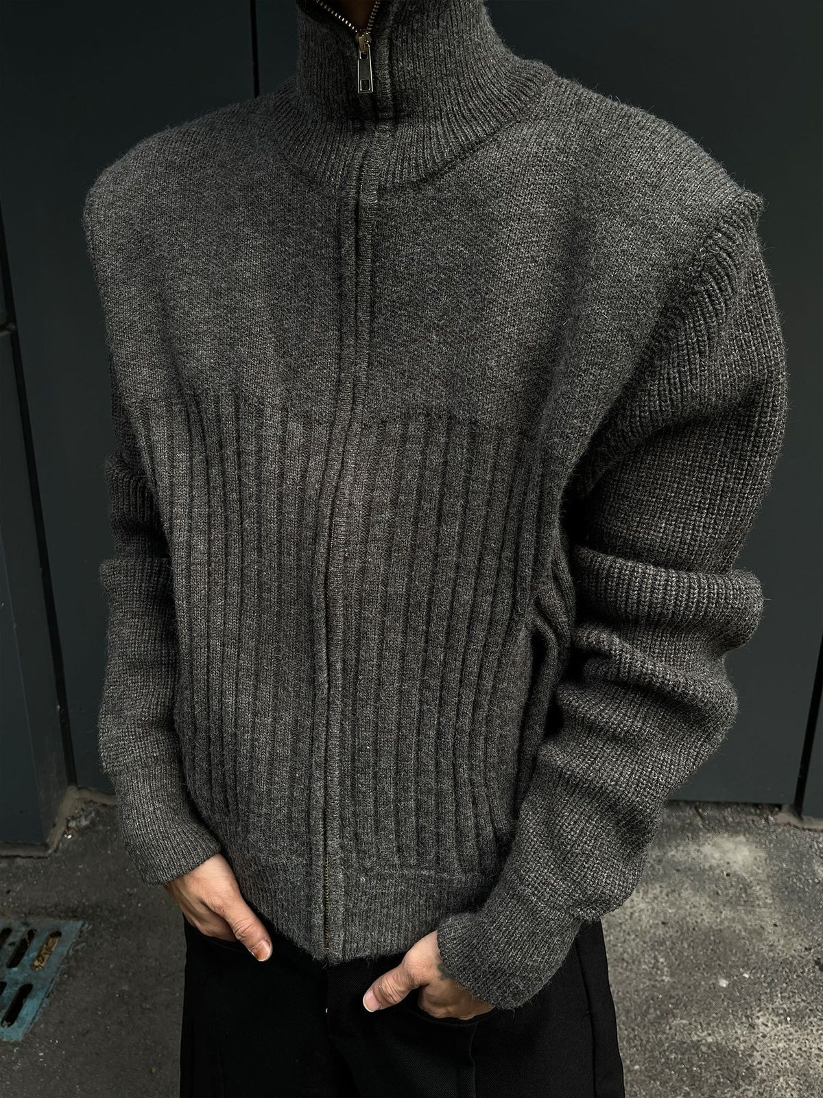 Torso view of the gray zip front knit cardigan showing the vertical rib panel on the chest and a ribbed sleeve