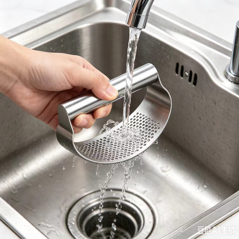Hand rinsing the stainless garlic press plate under a running kitchen tap over the sink