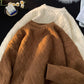 Brown and cream heavyweight knit pullovers laid flat showing the woven jacquard texture