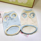 Sleeveless small dog vest with a back leash D-ring and a dachshund applique in the blue colourway on a small dog