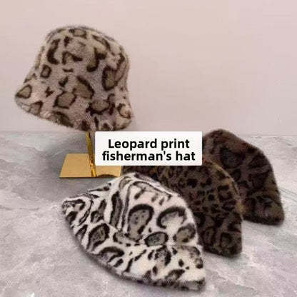 Leopard print plush bucket hats in cream, taupe and brown displayed on a gold stand with a label