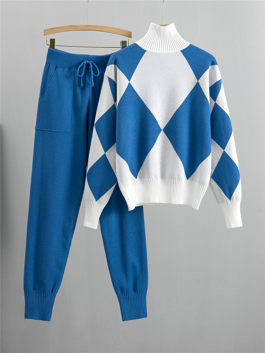 Blue argyle knit sweater with white panels and matching blue drawstring jogger pants on hangers against a white background