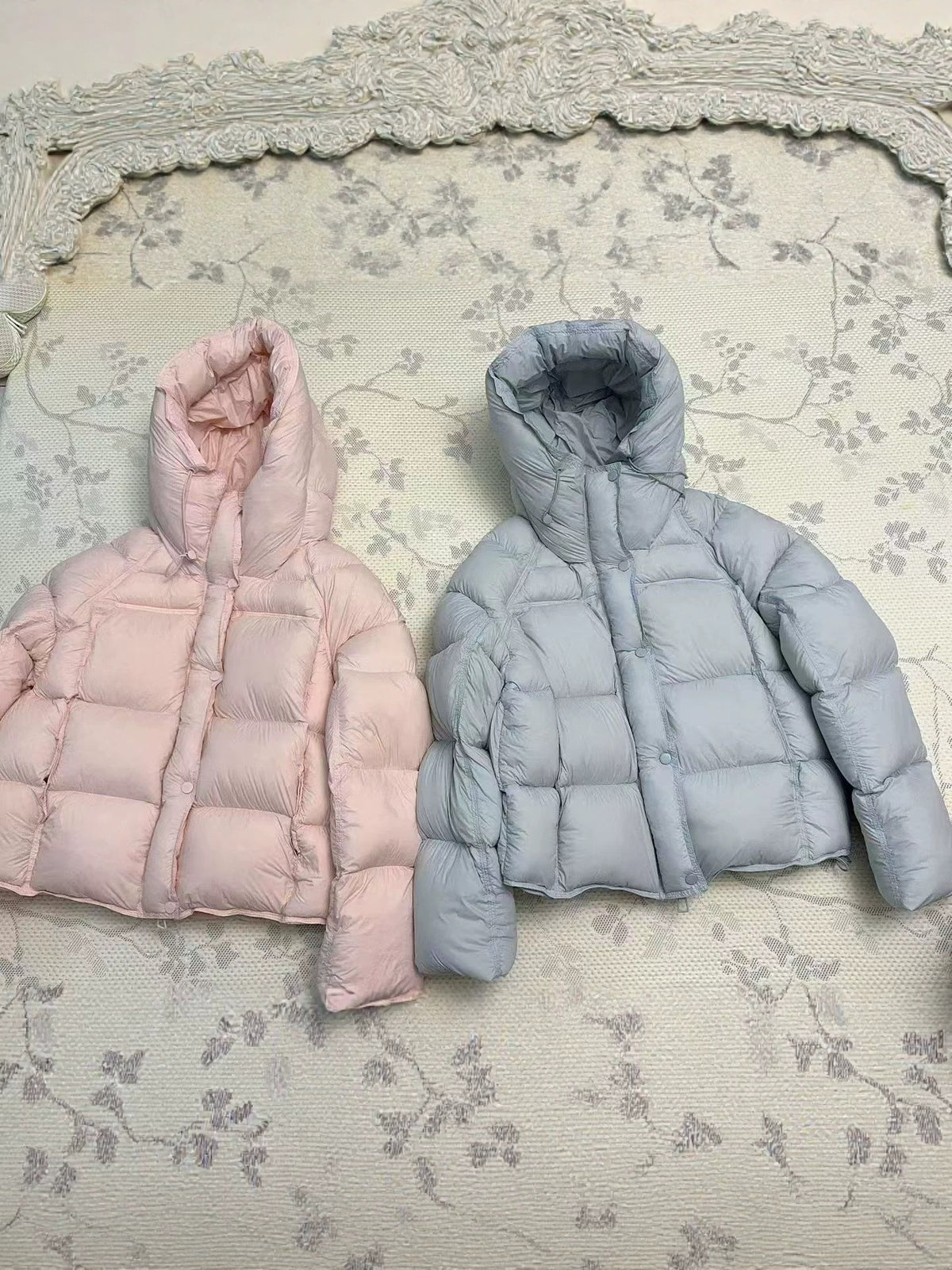 Hooded down puffer jacket shown flat, boxy short cut with a drawcord hood and front zip