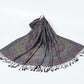 Black paisley shawl with a multicolor border and black tassels spread on a white background