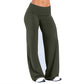 Woman in olive green fold over waist wide leg pants and white sneakers on a white studio background