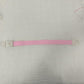 Single pink elastic quick release tourniquet band with a white snap buckle laid flat