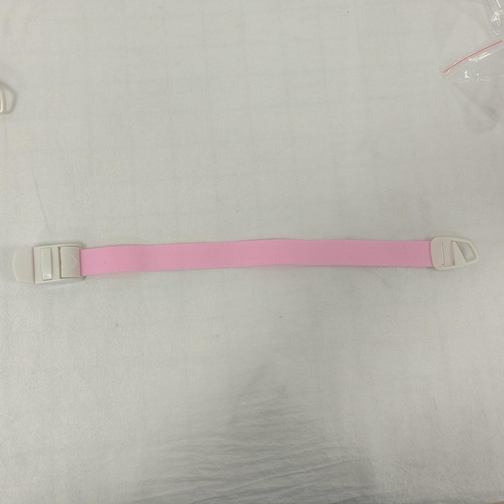 Single pink elastic quick release tourniquet band with a white snap buckle laid flat