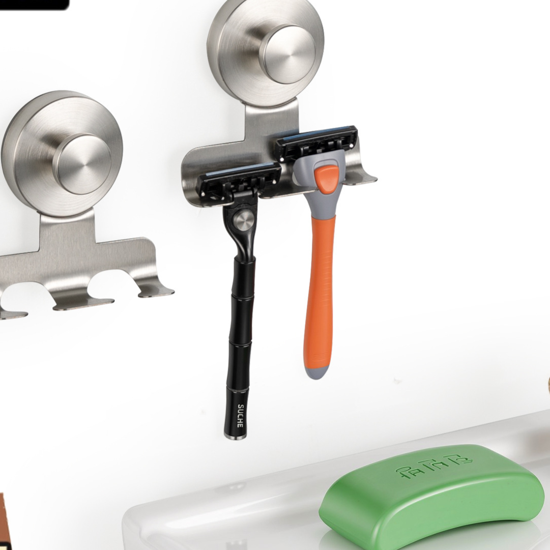 Black suction cup razor holder rack mounted on a smooth wall with open slots for razors