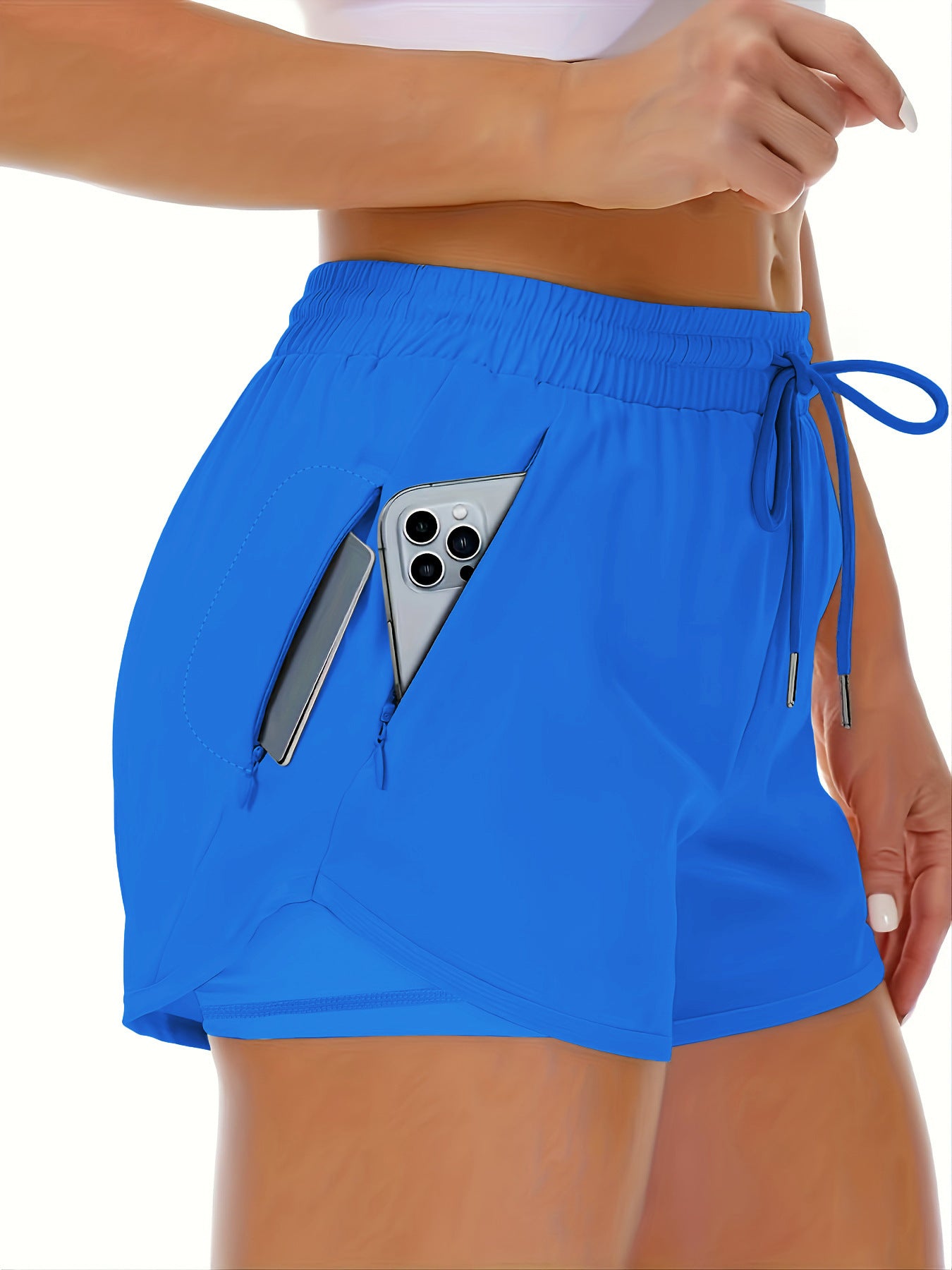 A red side view of womens running shorts showing the phone pocket holding a phone (2)
