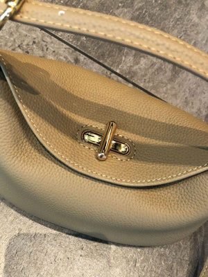 Soft cowhide bucket bag worn crossbody over the shoulder