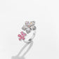 Two flower ring with clear pave petals above a smaller pink flower motif, white background