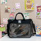 Front view of a clear window nylon shoulder bag with side drawcord and zip pocket