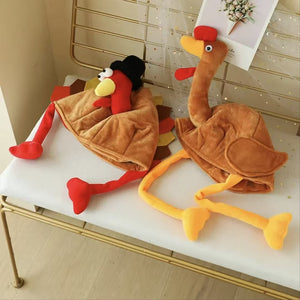 Two fleece turkey hats lying on a white bench, the pilgrim hat style with red legs and the long neck style with yellow legs