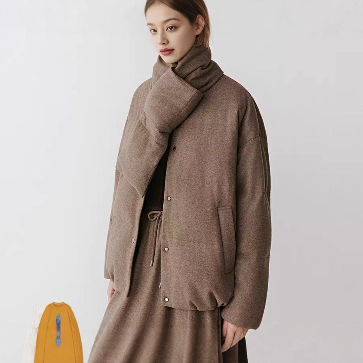 Loose mid length womens down jacket in heathered brown with attached scarf collar on white
