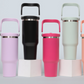 Row of insulated tumblers with handles in lavender, black, hot pink, sage green and coral on white blocks