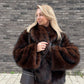 Dark red brown vegan fur short jacket with wide collar worn with brown trousers and a crossbody bag