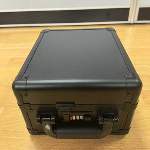 Black aluminium alloy card storage case closed, shown from the top on a wood floor