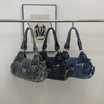 Three washed denim shoulder bags in blue, black and retro blue hung on a rail