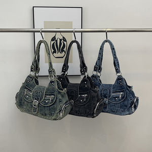 Three washed denim shoulder bags in blue, black and retro blue hung on a rail