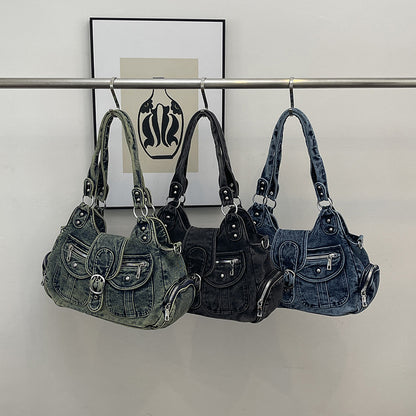 Three washed denim shoulder bags in blue, black and retro blue hung on a rail