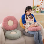 Pink and green flower shaped plush seat cushions on tub chairs in a bright room