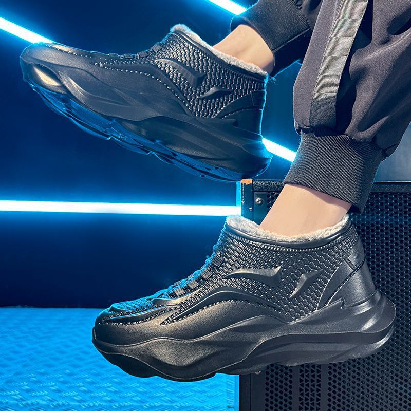 Black molded high top winter boot worn by a model in a blue neon studio