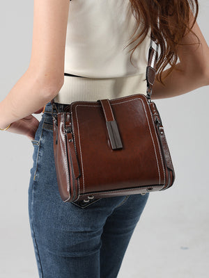 Oil wax cowhide bucket bag shown worn crossbody on model