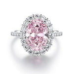 Light pink oval simulated diamond stone in a clear halo on a silver pave band, seen from above