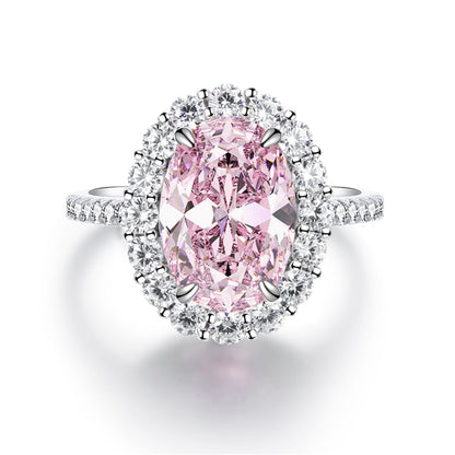 Light pink oval simulated diamond stone in a clear halo on a silver pave band, seen from above
