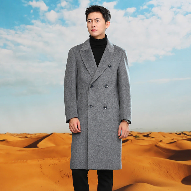 Man in a gray double breasted long coat in front of desert dunes, option photo for XL | US 42 / EU 52