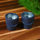 Two small dark grey resin fishing buckets with pale blue interiors on a wooden board