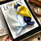 White blue and yellow color block printed square scarf with a satin sheen and hemmed edges, shown displayed
