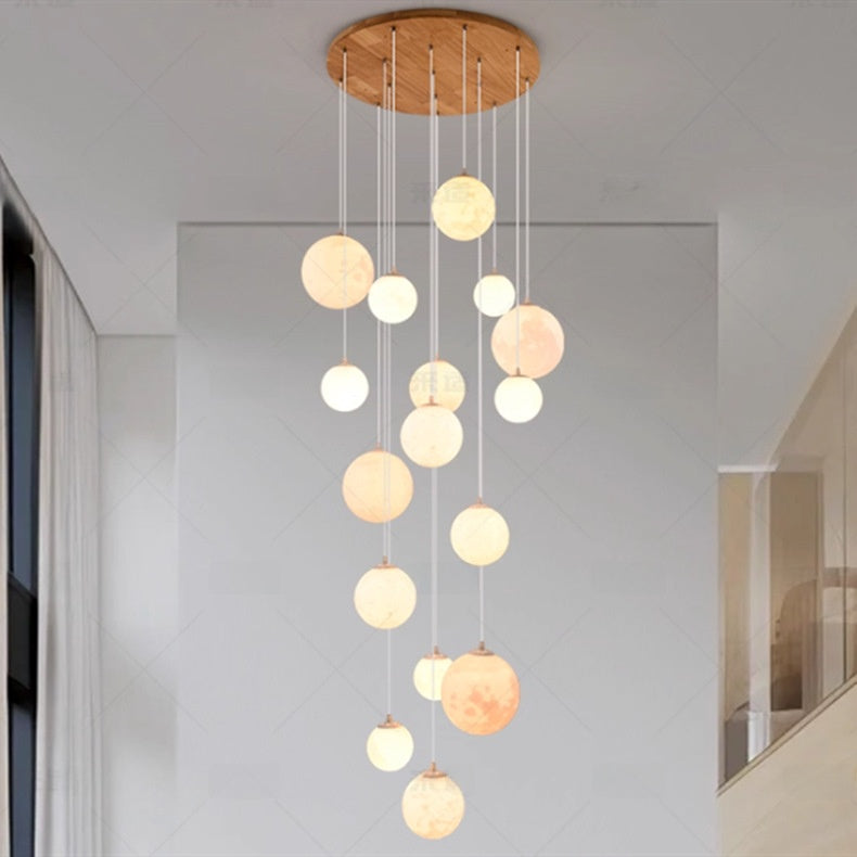 Globe chandelier shown installed above a staircase handrail
