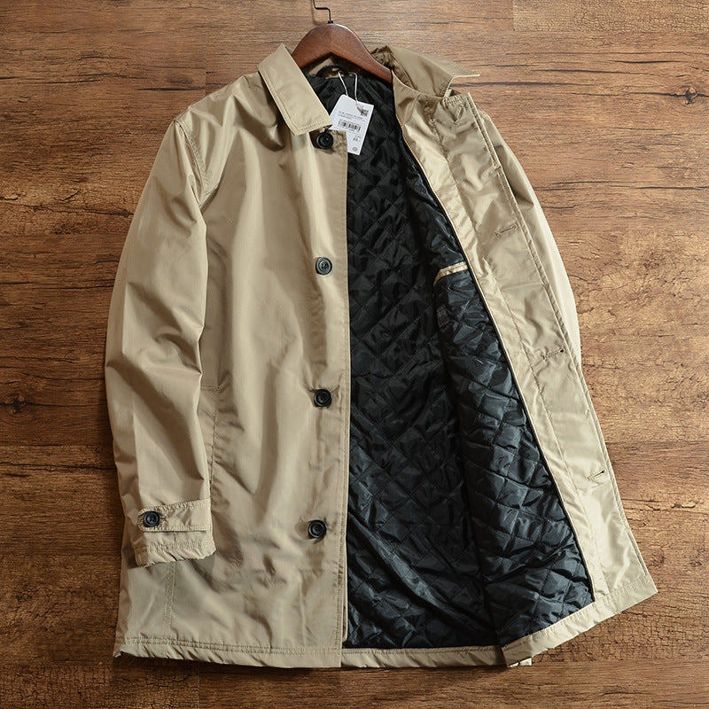 Khaki mid-length quilted lined coat with lapel collar and round buttons on a hanger, black diamond quilted lining visible