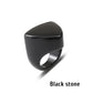 Black stone ring with an angular geometric face on a white background